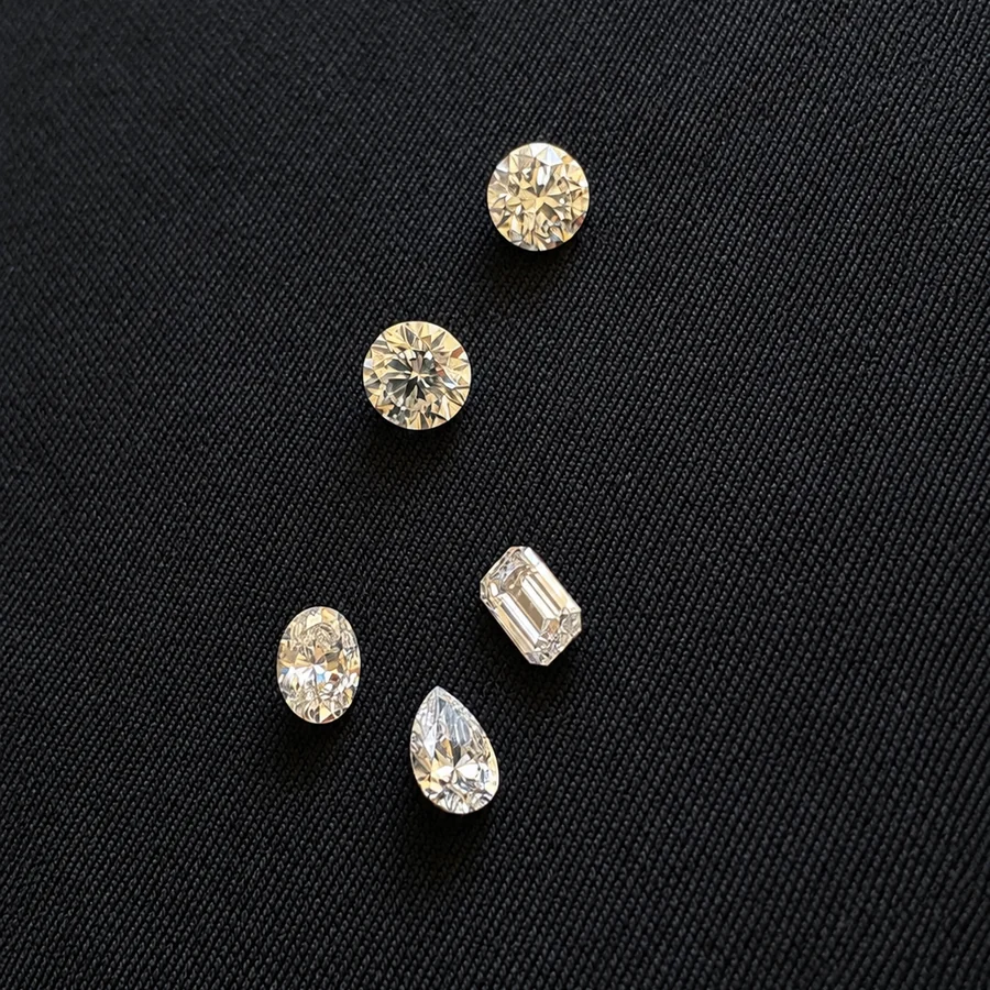 Five natural diamonds of mixed shapes laid out together on black fabric