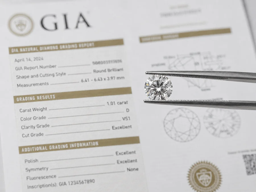 Un diamant taille brillant tenu à la brucelle au-dessus de son rapport de classification GIA