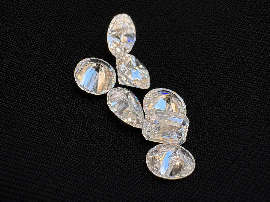 A group of loose diamonds in mixed shapes laid out together on black fabric